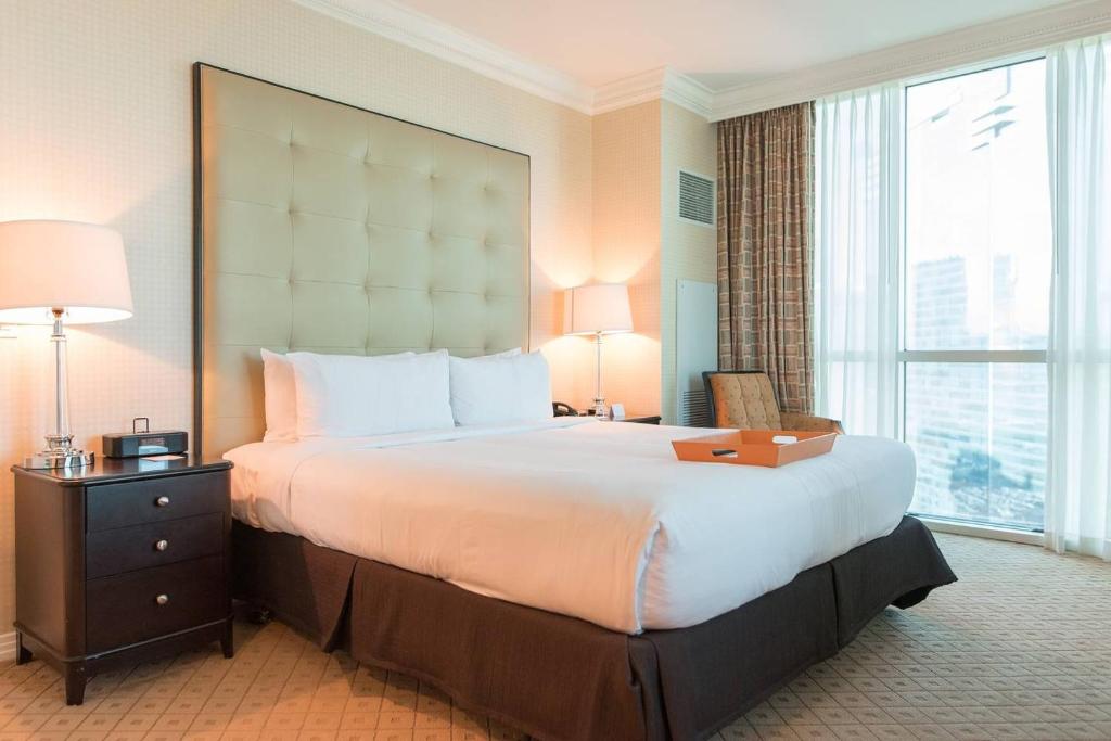 拉斯维加斯真正一卧室套房公寓式酒店 - 享有MGM招牌及大道的美景的一张位于酒店客房的大床,设有大窗户