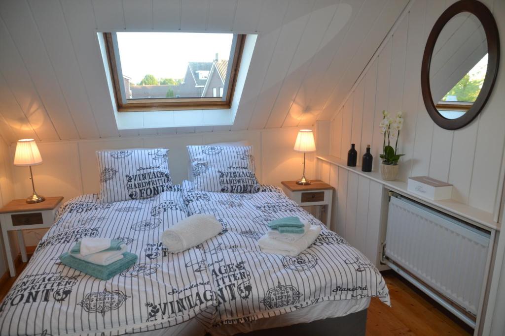 VierlingsbeekHerberg Thijssen的一间卧室配有一张大床、枕头和镜子