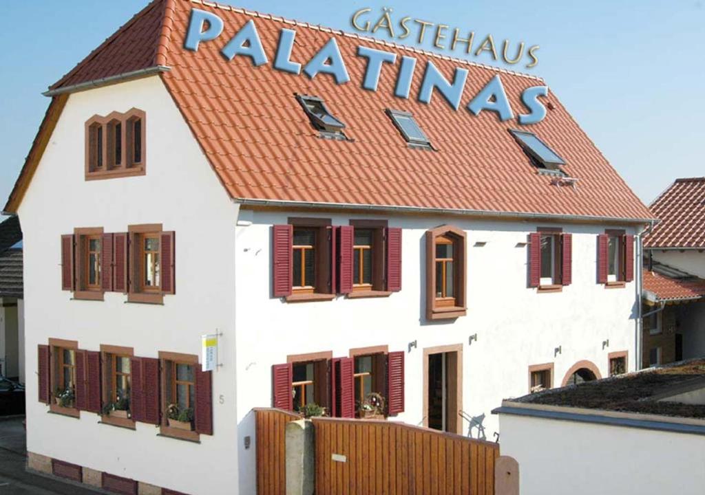 BöchingenGästehaus PALATINAS的白色的建筑,上面有标志