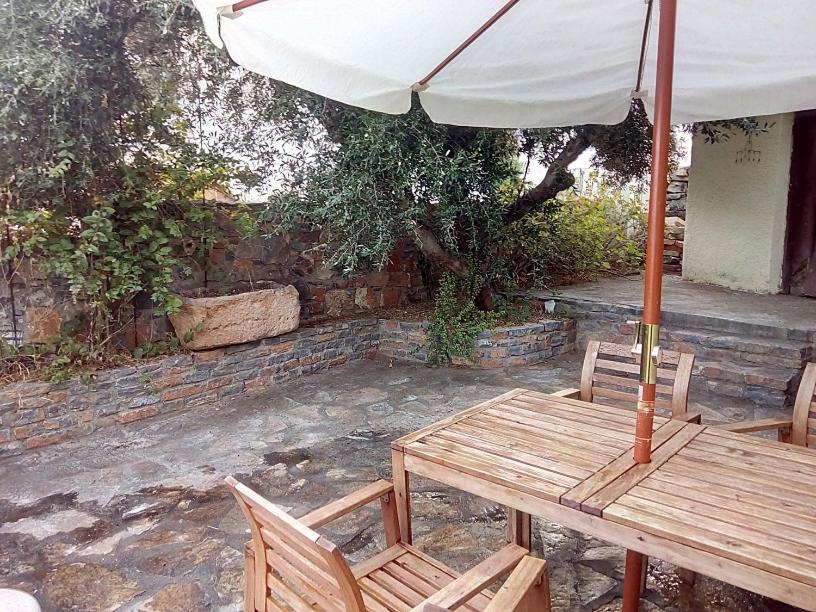 伊罗达Traditional House in Elounda的一张木桌和椅子及雨伞