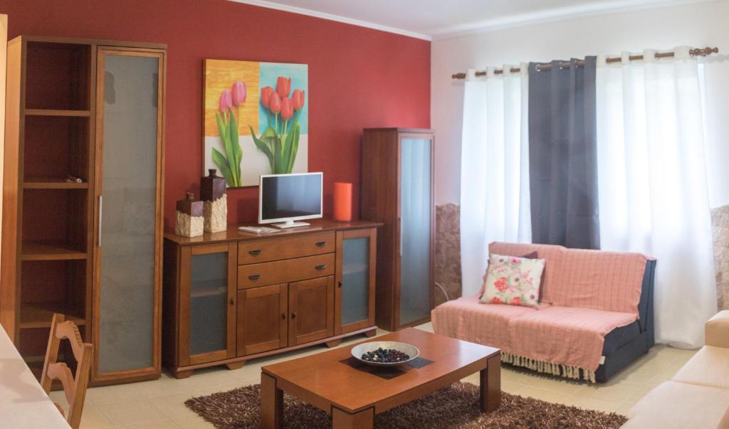 蓬塔德尔加达Apartamento Sandra的客厅配有电视、椅子和桌子