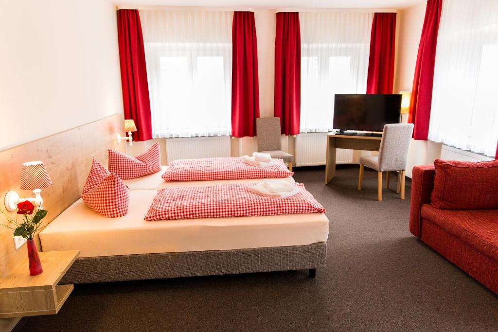 埃赫施塔特保加斯霍夫小号酒店的酒店客房带两张床和一张红色沙发