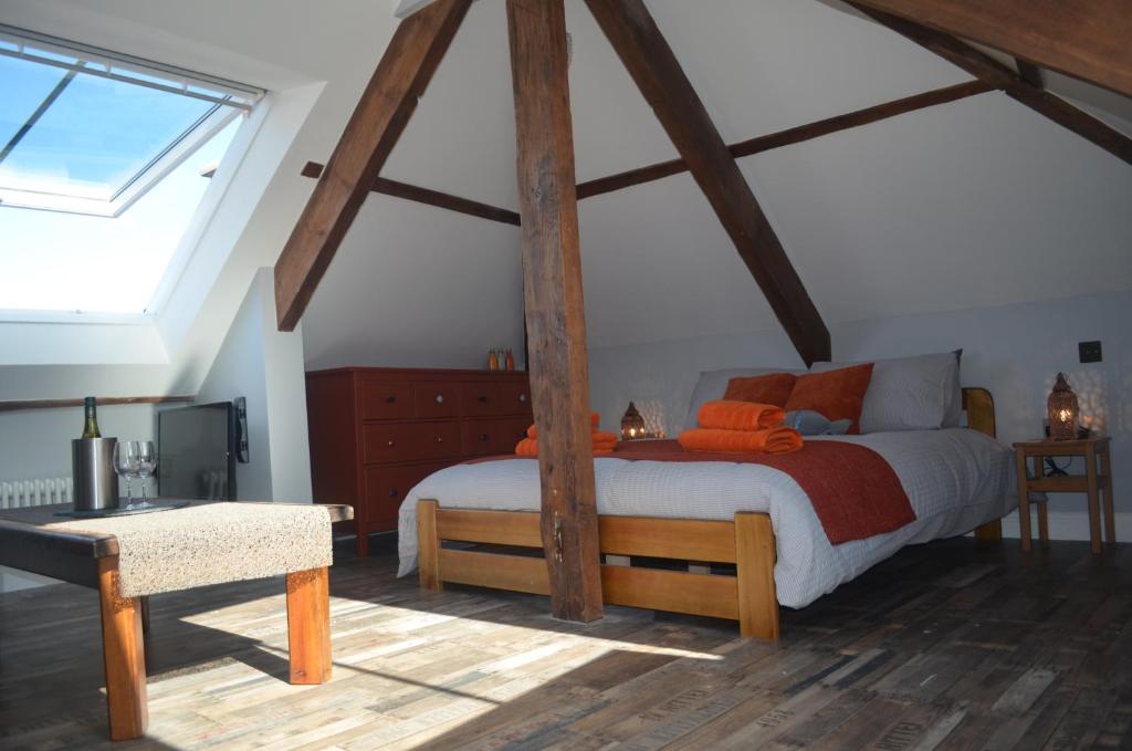 阿普尔多尔Appledore Factory的一间卧室设有一张带木梁的大床