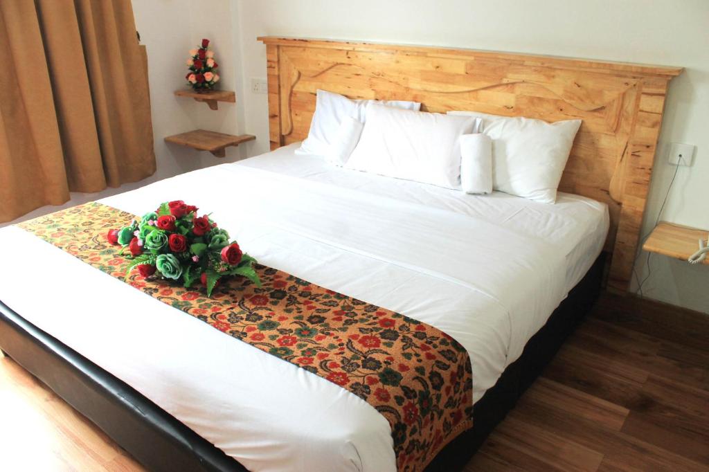 瓜拉丁加奴安特朗西酒店的卧室配有一张白色大床,拥有圣诞装饰