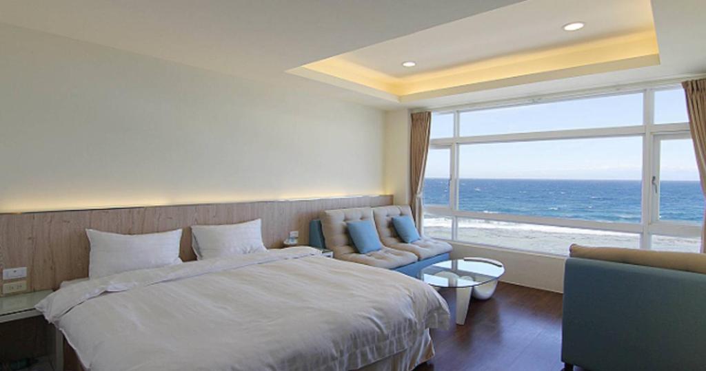 绿岛綠島 綠堤濱海旅店的一间卧室设有一张大床和一个大窗户