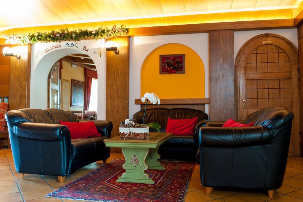 阿夏戈阿尔卑斯公寓式酒店的客厅配有皮椅和桌子