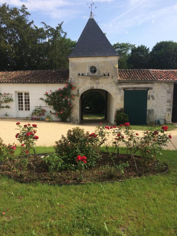 Chaniersle Logis du Plessis的一座老建筑,在院子里有门和鲜花
