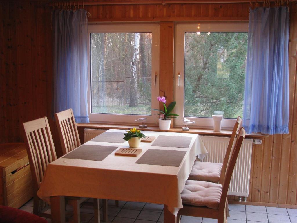 奥斯特西巴德钦诺维茨Ferienhaus Troge的一间带桌子和2个窗户的用餐室