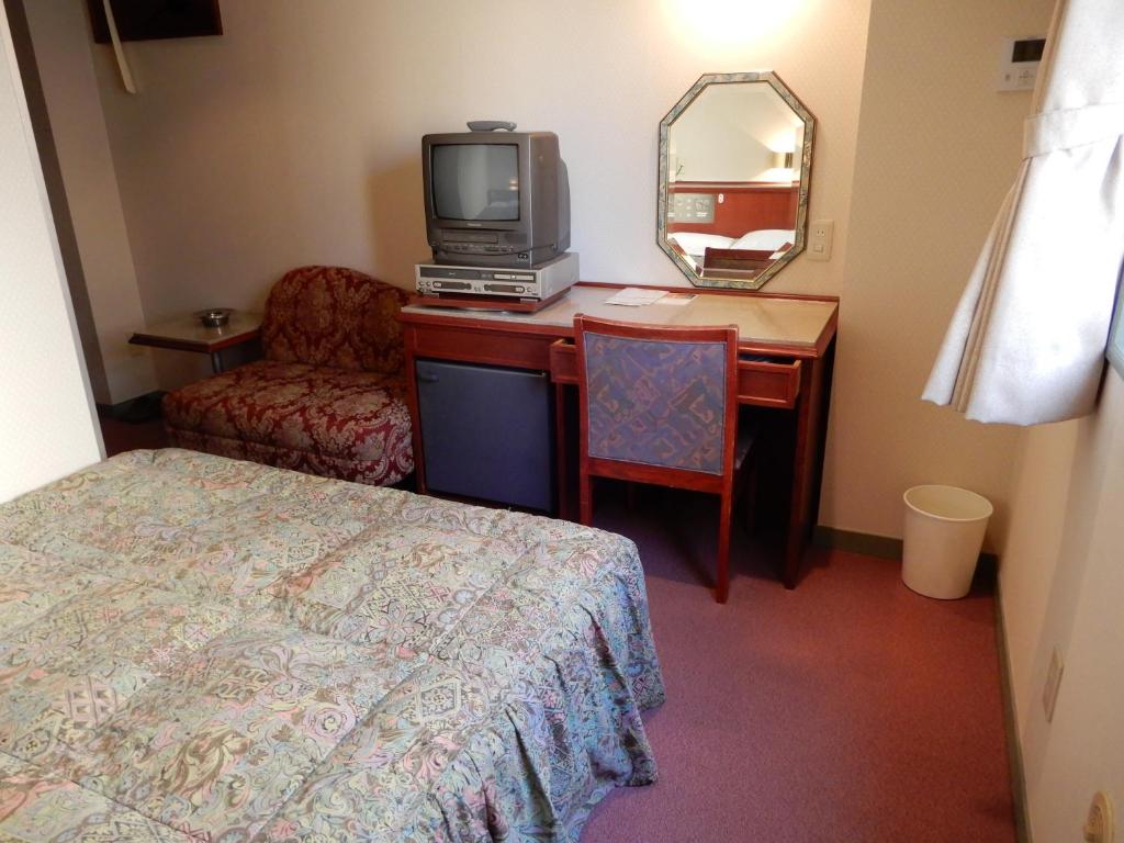 东京雷伊酒店的酒店客房配有一张床和一张书桌及一台电视