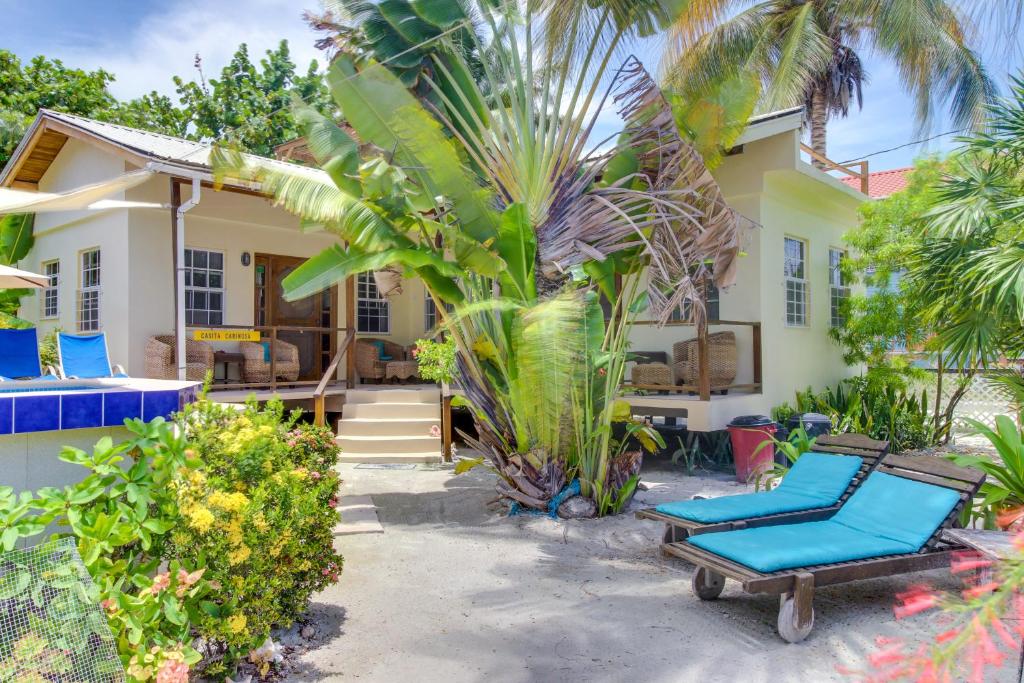 库尔克岛Amanda's Place Casita Carinosa - pool and tropical garden的前面有两把蓝色躺椅的房子