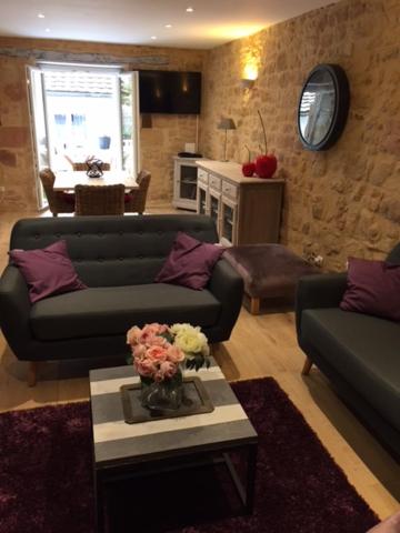 萨尔拉拉卡内达Le Nessmann的客厅设有两张沙发和一张鲜花桌