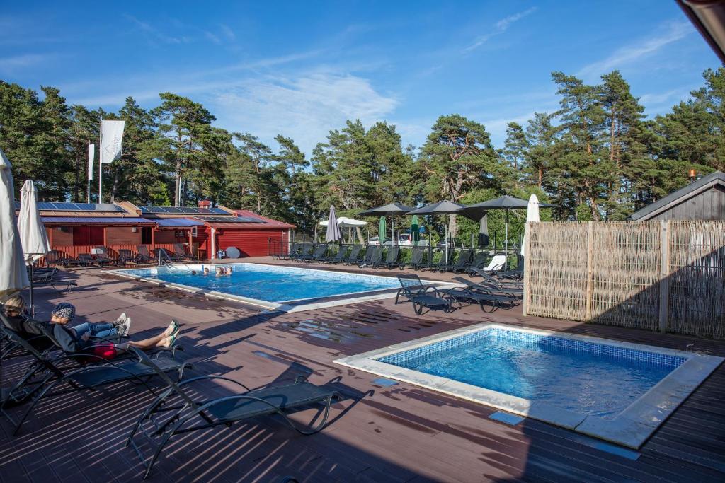 LjugarnLjugarns Semesterby的甲板上的游泳池,配有2张躺椅