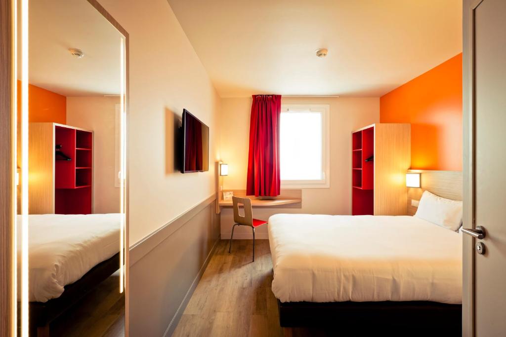 普雷夫桑莫昂Première Classe Genève - Aéroport - Prévessin的酒店客房,设有两张床和镜子