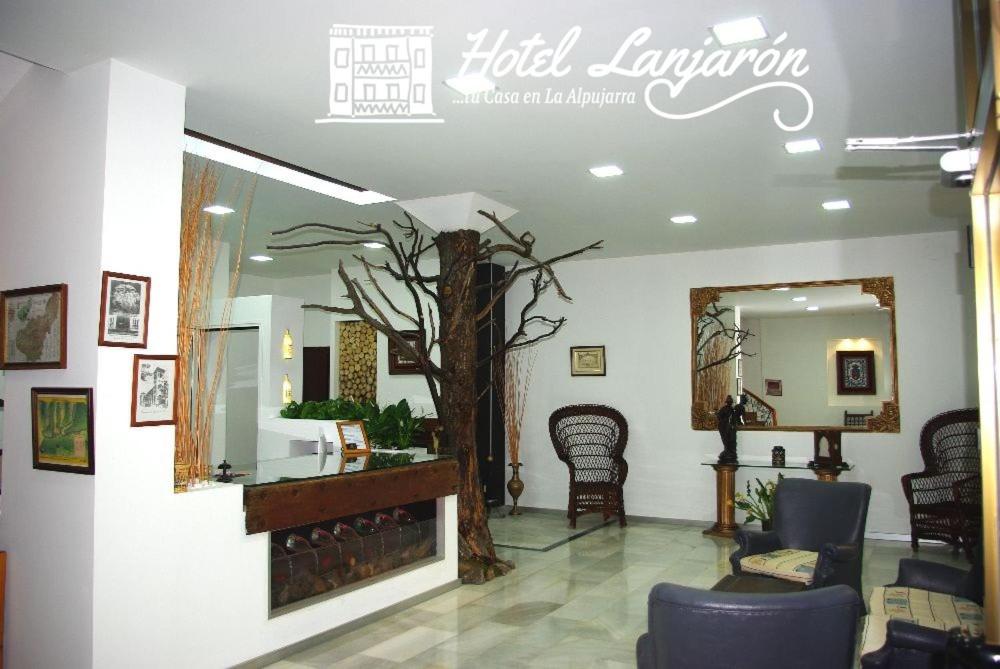 兰哈龙Hotel Lanjaron的一间位于房间中间的沙龙,里面有一棵树