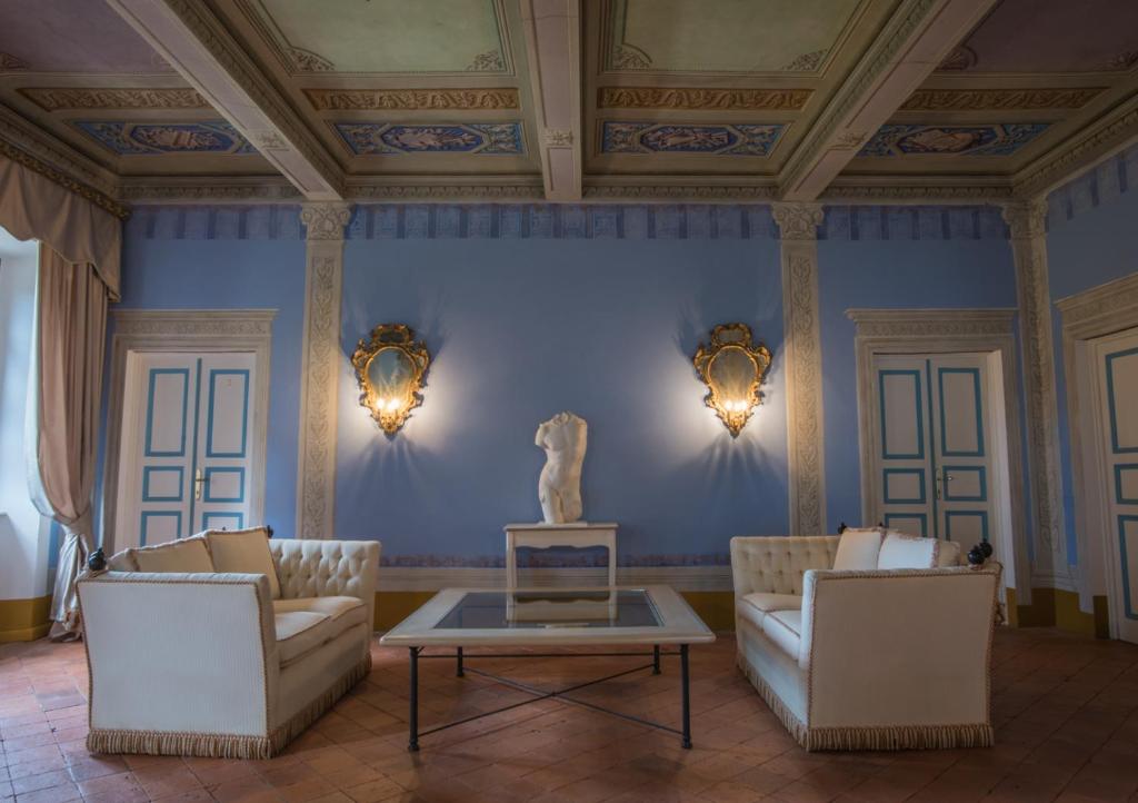 卡麦奥雷Relais Corte Rodeschi的客厅配有两张沙发和雕像