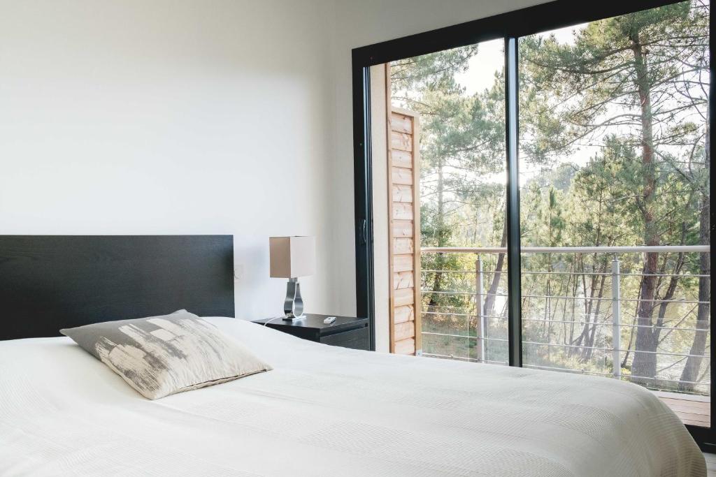 拉卡诺Villa Domaine de Pitrot的一间卧室设有一张床和一个大窗户