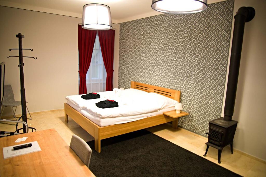 多布日什Penzion U tri statkaru的一间卧室配有一张床和一个燃木炉子