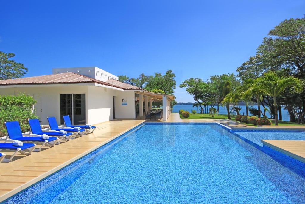 博卡奇卡滨海博卡斯酒店的别墅 - 带游泳池和蓝色椅子