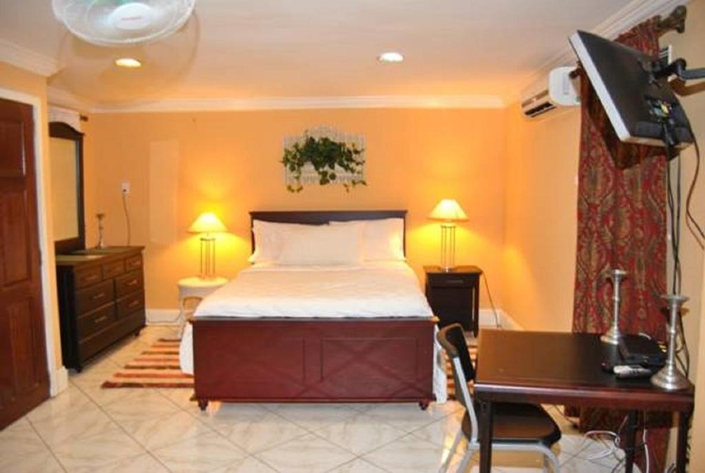 乔治敦El Dorado Inn的一间卧室配有一张床、一张书桌和一张书桌