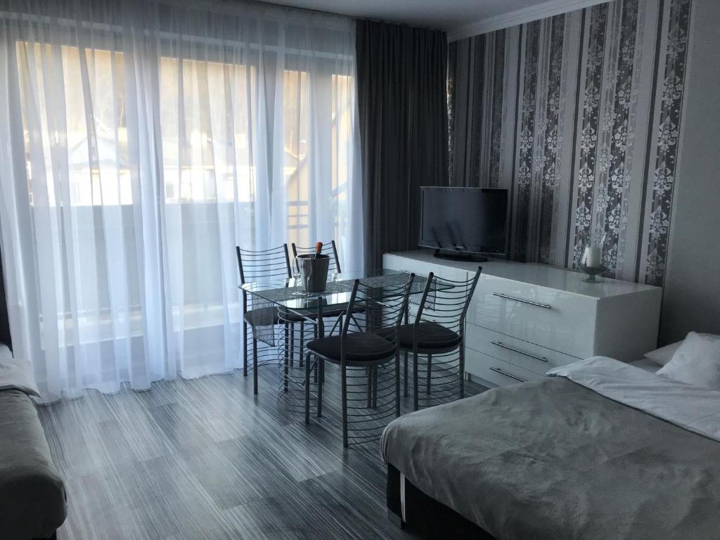 米兹多洛杰Apartament Villa Marea的酒店客房配有桌椅和一张床