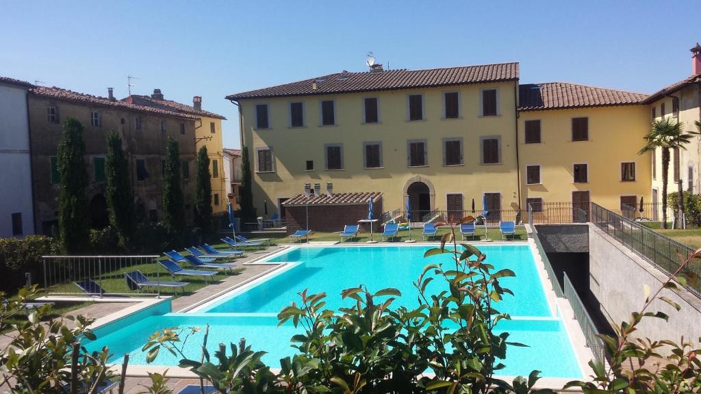 UsiglianoBorgo di Gramugnana的一座带椅子的游泳池以及一座建筑