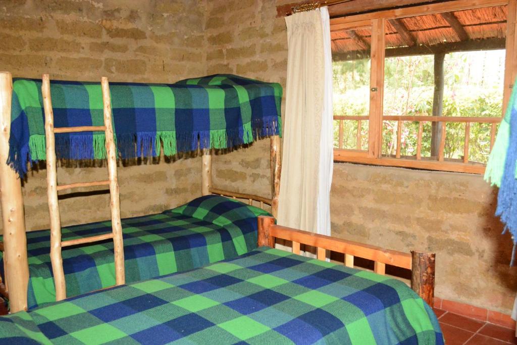 El BarrialMonzaque- paraíso de bachué的一间卧室设有两张双层床和一扇窗户。