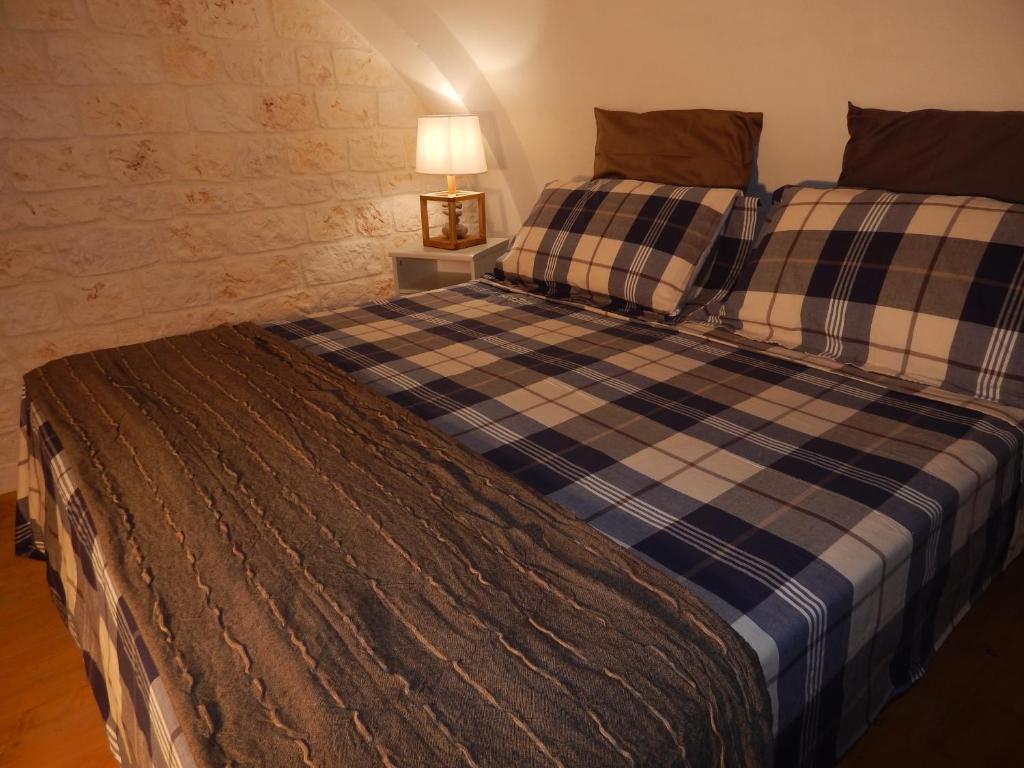滨海波利尼亚诺Casa Pascal的一间卧室配有一张大床和一张铺着条纹毯子
