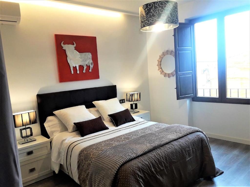 乌贝达Apartamentos Sol Compañia的卧室配有一张挂有山羊画的床。