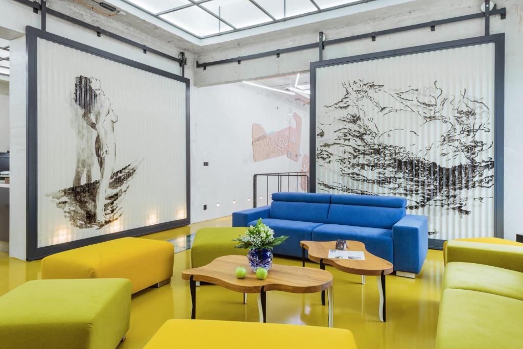 奥洛穆茨Smarthotel Nezvalova Archa的一间设有黄色和蓝色椅子及桌子的房间
