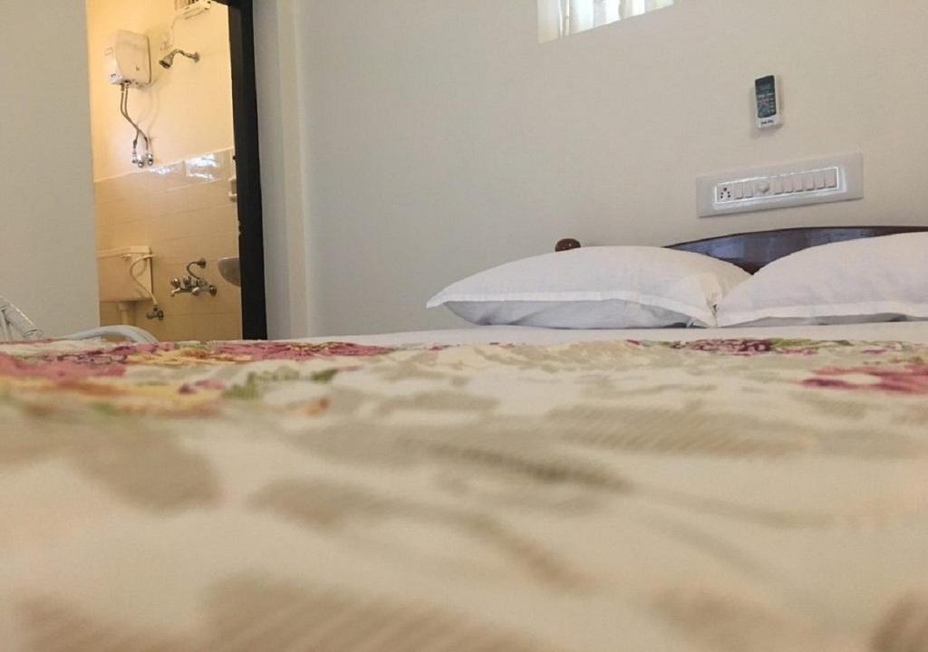 科钦Padamadan homestay的一间卧室配有带白色枕头的床