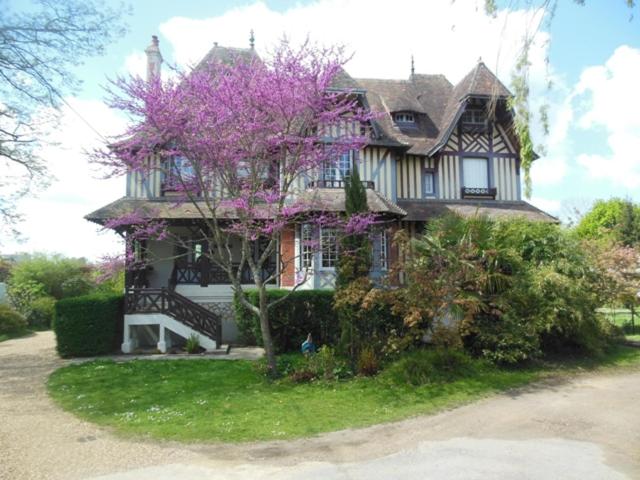 蓬莱韦克Maison d'hôtes Il était une fois的前面有一棵紫色的树的房子