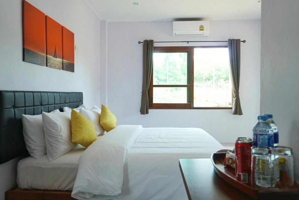 库德岛The Lodge at Koh Kood的带白色床和窗户的卧室