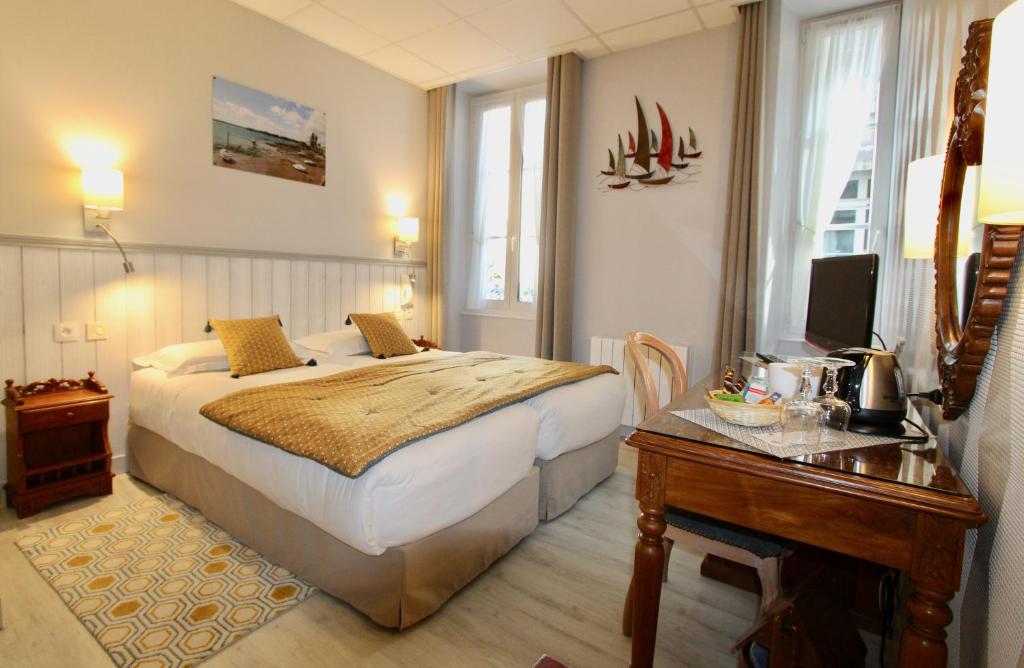 圣马洛德斯阿博斯酒店的一间卧室配有一张床和一张书桌及电视