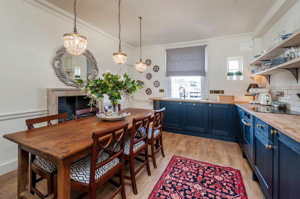 巴斯Luxury Regency Apartment in Bath City Centre的厨房配有木桌和蓝色橱柜。