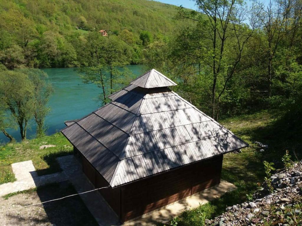 BeserovinaBrvnara na obali reke Drine的水体旁边的小建筑