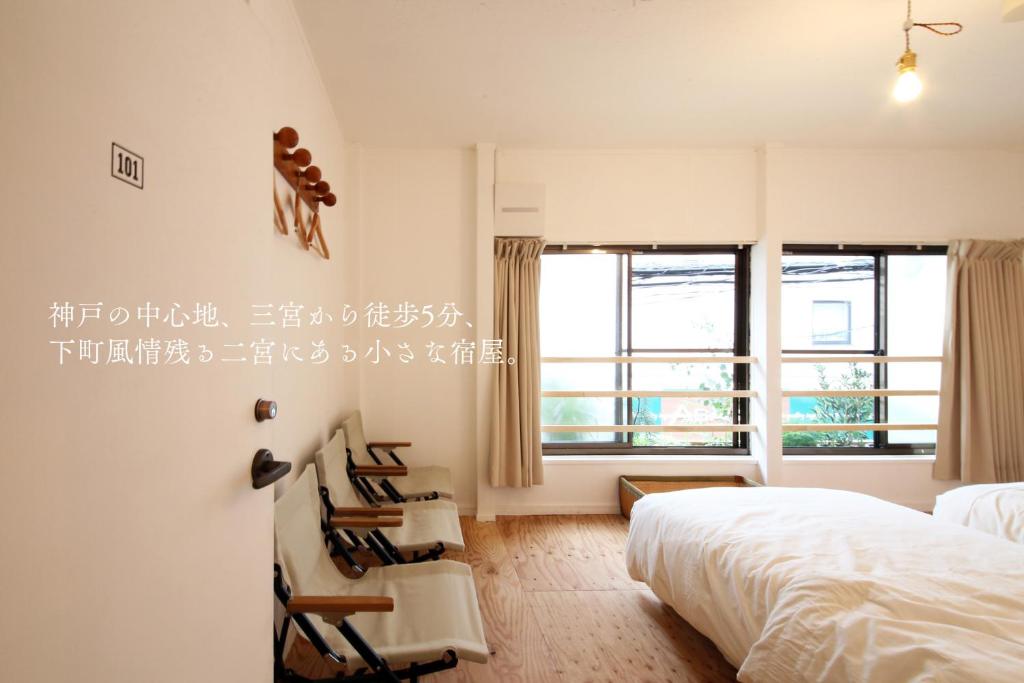 神户居家公园旅馆的一间卧室配有床、椅子和窗户