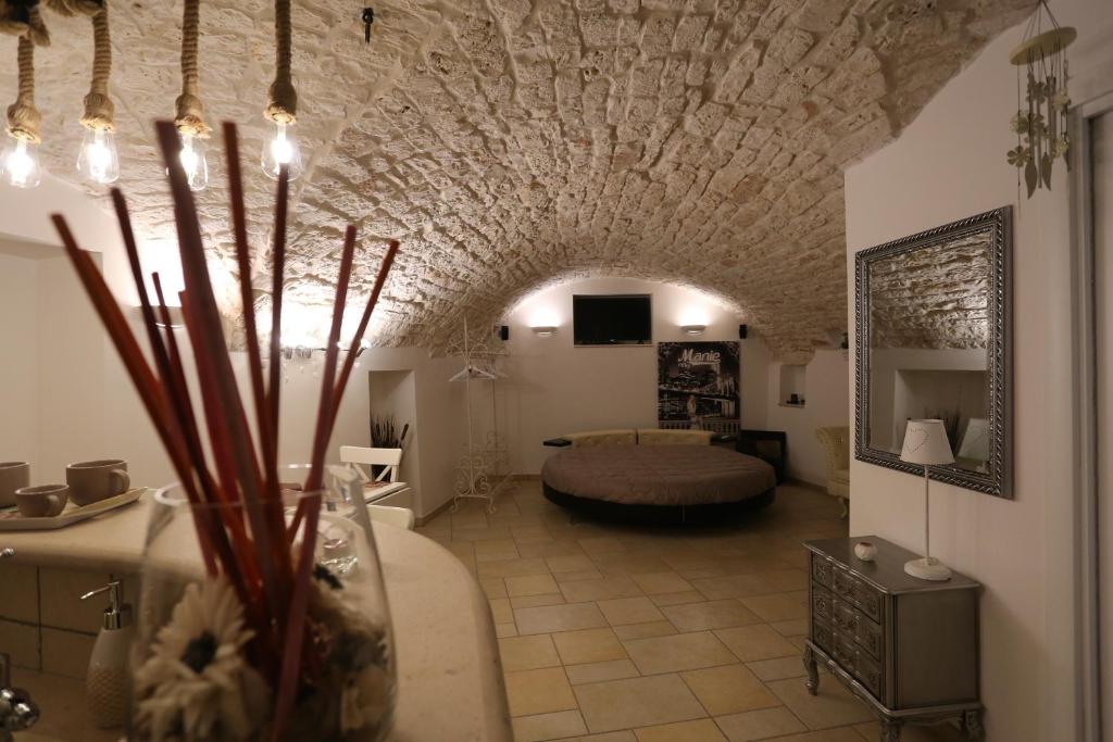 普蒂尼亚诺Casa Vacanze Il Rifugio Del Principe的一间客厅,客厅内配有一张位于石头天花板的房间的床