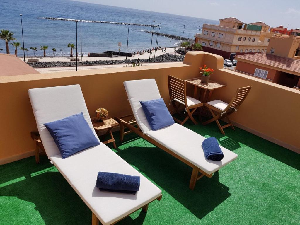 圭马尔港¡Amazing place!的一个带两把椅子和一张桌子的阳台以及海滩