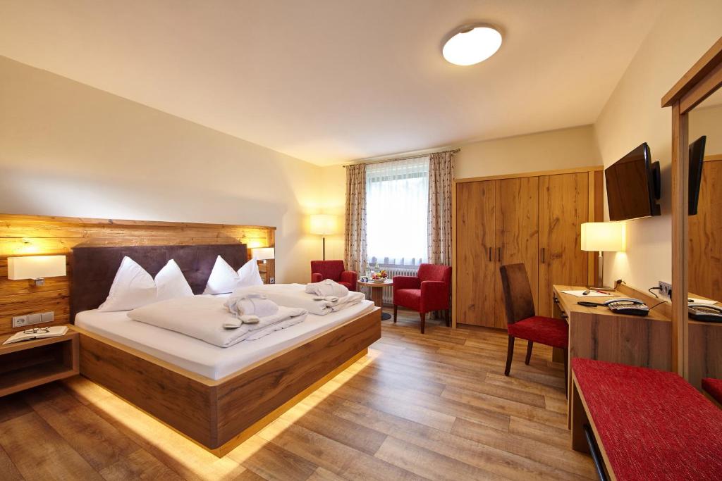 绍尔格鲁布AURA-HOTEL Saulgrub的配有一张床和一张书桌的酒店客房