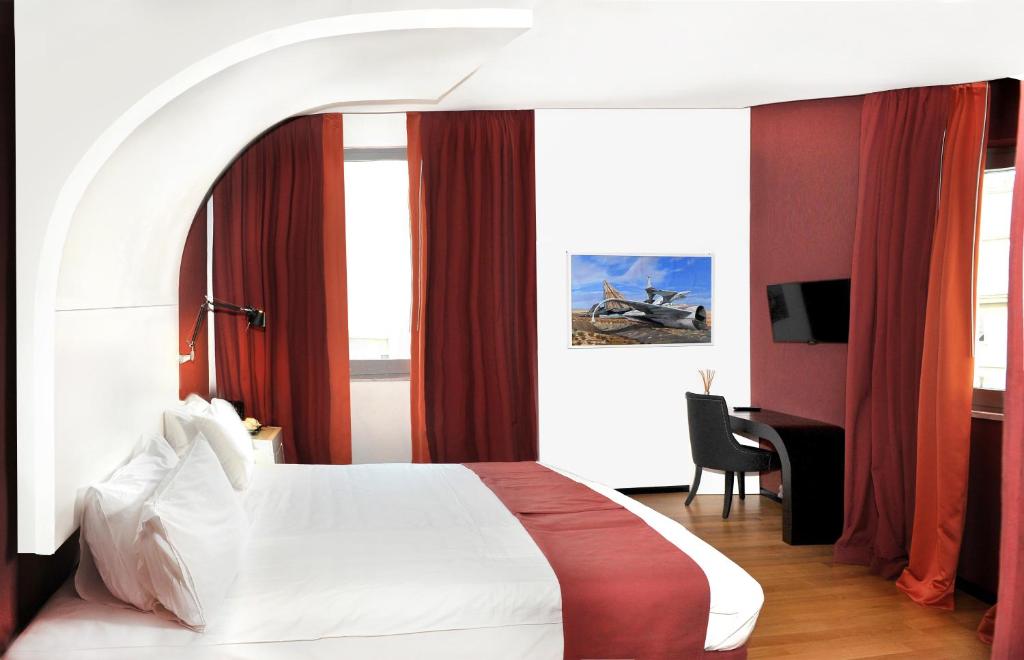 那不勒斯特罗斯托里科文化酒店的卧室配有白色的床和红色窗帘