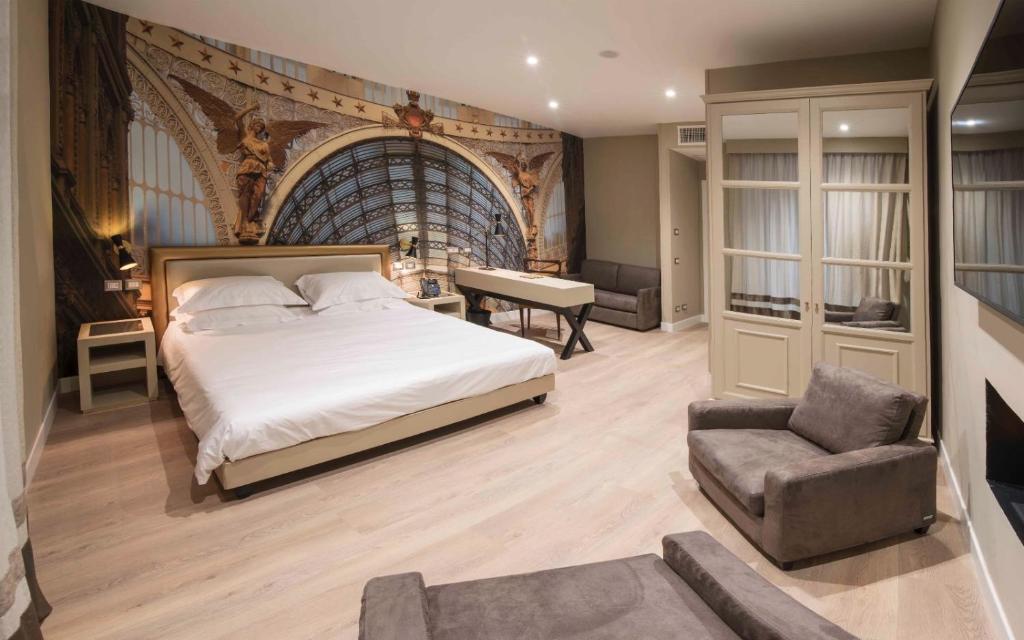 那不勒斯卡鲁索广场精品和健康套房酒店的一间卧室配有一张床、一把椅子和一张书桌
