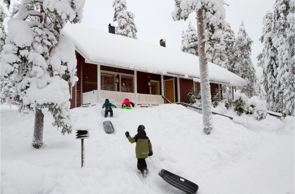 罗瓦涅米Villa Kyyhkynen的站在房子前的雪中的人