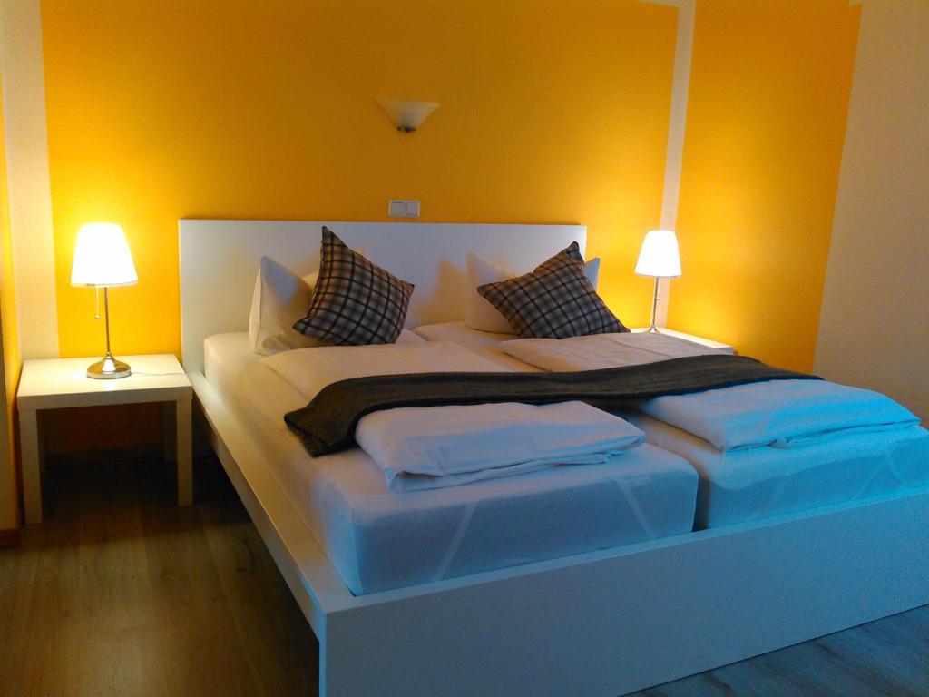 魏玛波森多夫兰德酒店的一张大床,位于带两盏灯的房间