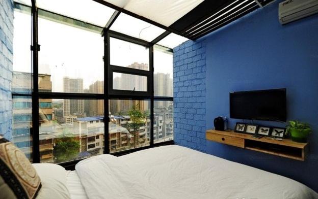 贵阳贵阳墅国际青年旅舍的蓝色的客房设有床和大窗户