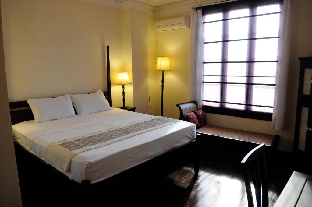 万象Hotel Khamvongsa的一间卧室设有一张大床和一个窗户。
