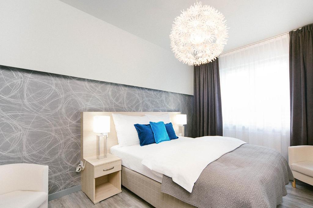 卡托维兹ActivPark Apartments的一间卧室配有一张床和一个吊灯