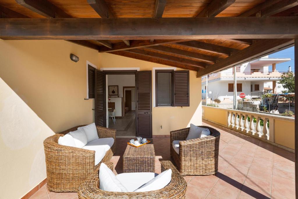 莱乌卡Girasole by BarbarHouse的阳台的庭院配有藤椅和桌子