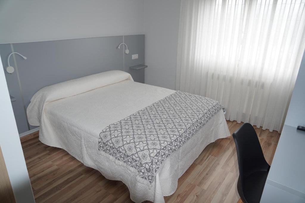 波尔托马林Pension Perez的一间卧室配有一张床铺,床上有毯子