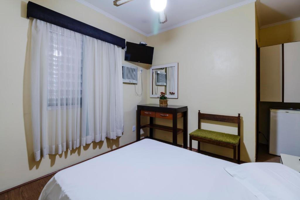 南圣卡埃塔诺Hotel Acacia的卧室配有床、椅子和窗户。