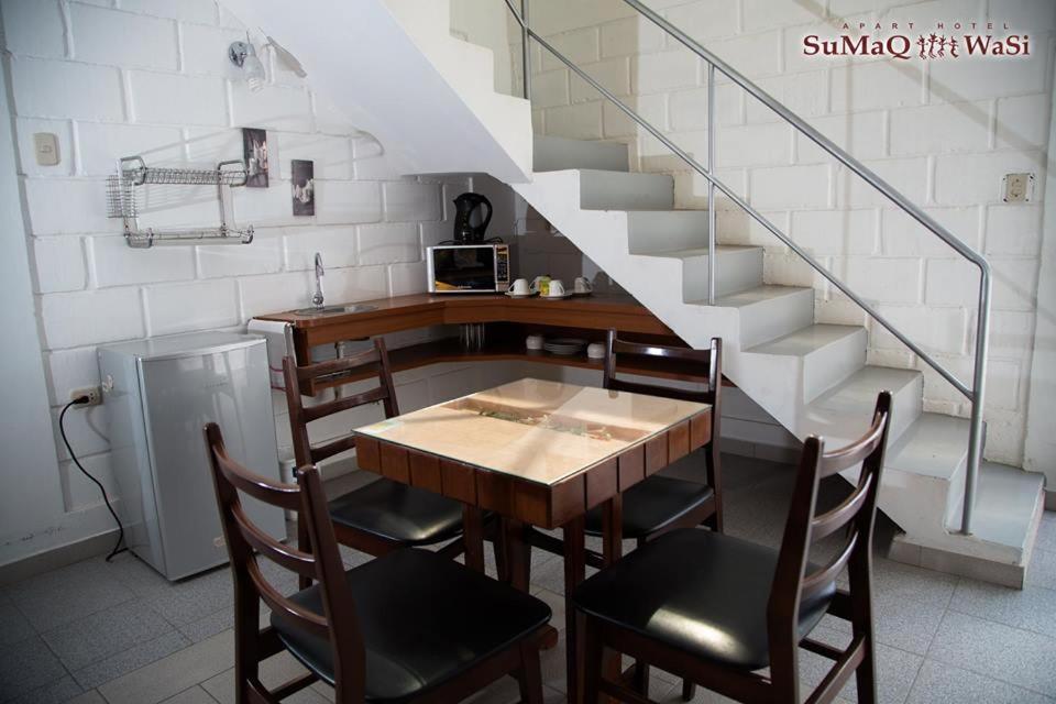 塔克纳Sumaq Wasi Apart Hotel的一间带桌椅和楼梯的用餐室